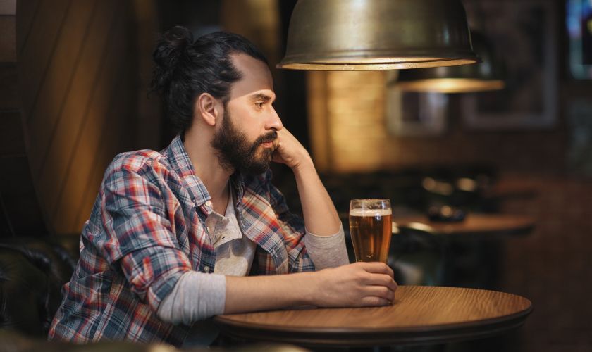 La depresión postvacacional aumenta el riesgo de desarrollar adicciones y de recaídas. La depresión postvacacional aumenta el riesgo de desarrollar adicciones y de recaídas: hombre pensativo bebiendo solo en un bar.