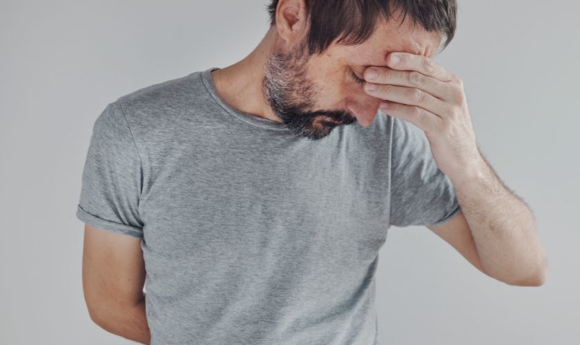 Cómo afecta el consumo de alcohol, incluso en pequeñas cantidades, al sueño y la memoria Cómo afecta el consumo de alcohol, incluso en pequeñas cantidades, al sueño y la memoria: hombre joven con manos en la cabeza tiene sueño y le cuesta recordar algo.