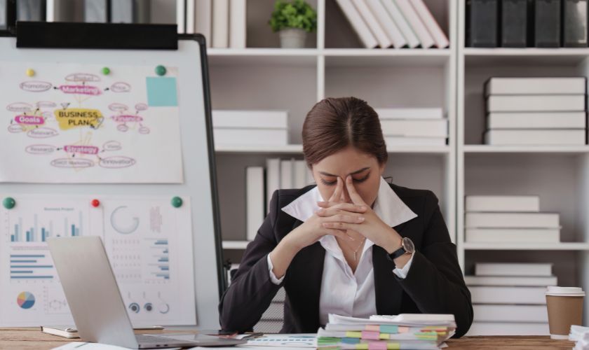 Impacto del consumo moderado de alcohol en el trabajo y los estudios Impacto del consumo moderado de alcohol en el trabajo y los estudios: mujer joven en mesa de oficina con sueño y problemas de concentración.