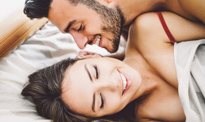 Estrategias de autoevaluación que ayudan a diferenciar si hay un problema de alta libido o de adicción al sexo. Estrategias de autoevaluación que ayudan a diferenciar si hay un problema de alta libido o de adicción al sexo: hombre sonriendo sobre mujer en la cama.
