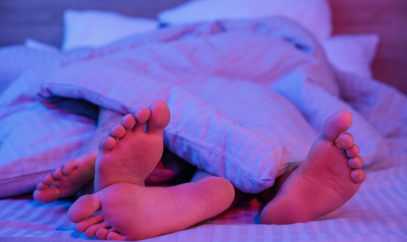 Obstáculos más frecuentes para recuperar una vida sexual saludable tras un problema de adicción al sexo: pies de una pareja bajo las sábanas en la cama.